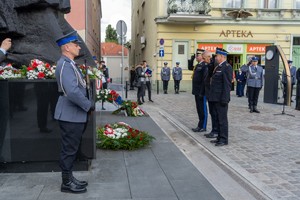 Uczestnicy uroczystości składają kwiaty pod pomnikiem