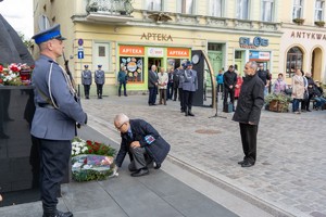 Uczestnicy uroczystości składają kwiaty pod pomnikiem