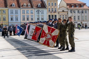 policjanci i żołnierze pochylają sztandary w stronę pomnika