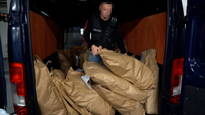 policjant chwyta papierowy duży worek z narkotykami