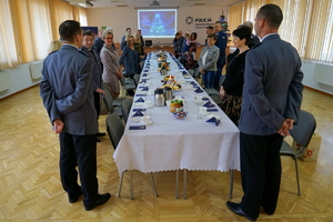 Komendanci i zaproszeni goście stoją przed stołami