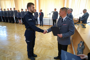 Komendant przekazuje akt ślubowania policjantowi