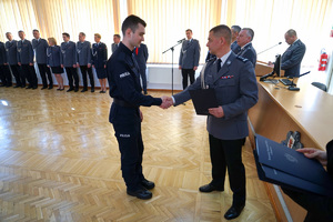 Komendant przekazuje akt ślubowania kolejnemu policjantowi