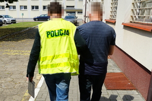 Policjant prowadzi zatrzymanego