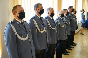 siedmiu policjantów z kadry kierowniczej stoi w szeregu przy oknie