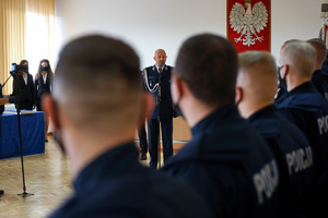 nowoprzyjęci policjanci patrzą  na przemawiającego Komendanta