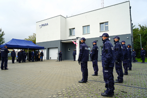 widok na budynek. Przed posterunkiem stoją w szeregu policjanci