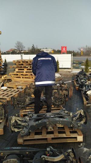 Policjant stoi nad częściami samochodowymi