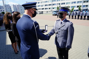 Komendant gratuluje policjantowi wyróżnienia odznaką honorową policjantowi Za zasługi podczas działań poza granicami RP