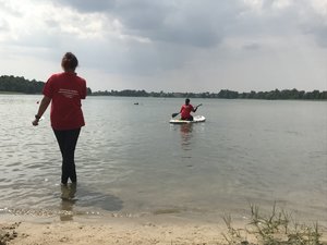 Ratownik płynie na desce w stronę pozoranta