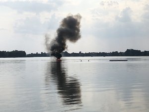 widok na łódź z której wydobywa się czarny dym