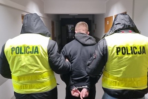 Policjanci prowadzą zatrzymanego mężczyznę