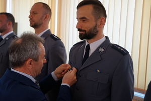 Prezes PCK przypina odznakę policjantowi