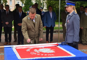 urzędnik przybija młoteczkiem gwóźdź do sztandaru