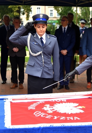 policjantka oddaje honor przed sztandarem