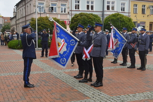 Komendant Powiatowy Policji w Tucholi oddaje honor policjantom, którzy trzymają sztandar