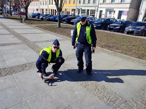 Policjant z dronem, a obok stoi policjant ruchu drogowego