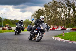 Dwóch policjantów jedzie na motocyklach po torze wyścigowym