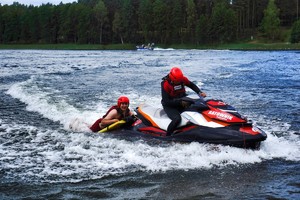 dwóch ratowników medycznych na płynącym skuterze wodnym