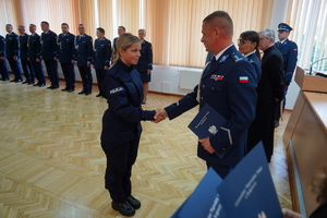 Komendant podaje rękę policjantce i wręcza rozkaz o przyjęciu do służby