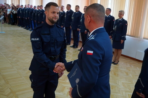 Komendant podaje rękę policjantowi i wręcza rozkaz o przyjęciu do służby