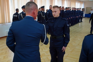 Komendant podaje rękę policjantowi i wręcza rozkaz o przyjęciu do służby