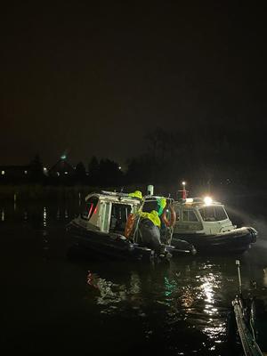 dwie łodzie płynące po jeziorze po zmroku