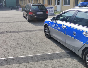 Pod szpitalem stoi radiowóz, a przed nim auto, którym jechała ciężarna