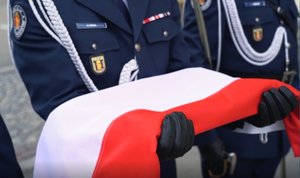 2 maja 2020 roku. Dzień Flagi Rzeczypospolitej Polskiej. Policjanci 1 kompanii Oddziału Prewencji Policji w Warszawie wciągają flagę na maszt przed Pałacem Mostowskich, siedzibą Komendy Stołecznej Policji.