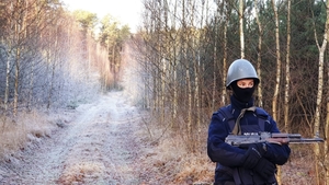 policjant podczas ćwiczeń w lesie.