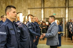 Zastępca Komendanta Wojewódzkiego Policji w Łodzi składa gratulacje policjantom podczas ślubowania.