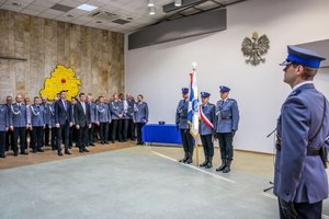 Kadra kierownicza łódzkiej policji, obok poczet sztandarowy.