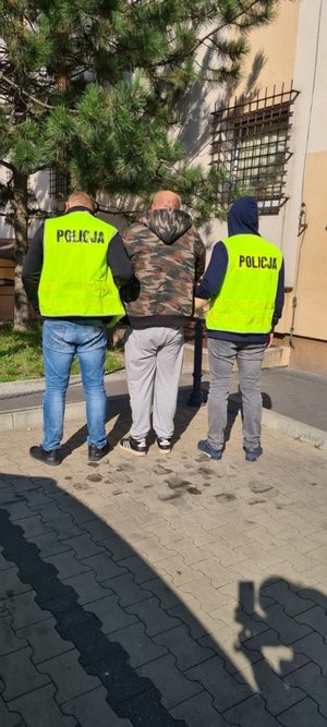 Policjanci prowadzą zatrzymanego.