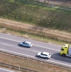 policyjny oznakowany radiowóz podczas patrolowania autostrady, zdjęcie zrobione z góry z pokładu śmigłowca