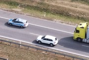 oznakowany radiowóz na autostradzie , w otoczeniu ciężarówka i samochód osobowy