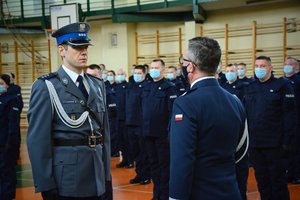 Sala gimnastyczna oddziału prewencji policji w Łodzi, uroczystość ślubowania, dowódca uroczystości składa meldunek komendantowi.