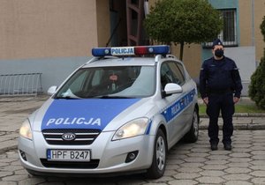 Radiowóz oznakowany i policjant.