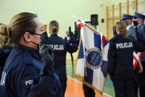 Policjanci stojący przed pocztem sztandarowym.