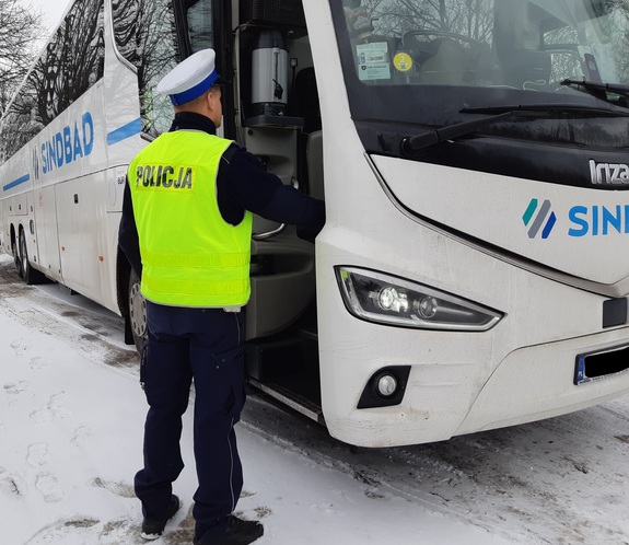 Policjant przy autokarze.