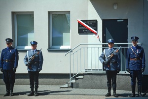 Policjanci stojący przed pamiątkową tablicą.
