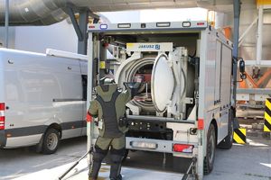 Policjant w stroju pirotechnicznym przed pojazdem.