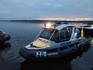 Policyjna łódź na zalewie wieczorową porą.