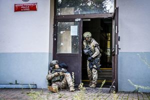 Policjanci ochraniają wejście do budynku.