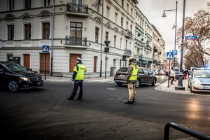 policjanci zabezpieczają szczyt OBWE, policjant i funkcjonariusz SOP kierują ruchem na skrzyżowaniu