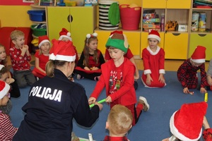 Policjantka w czapce mikołaja z dziećmi.