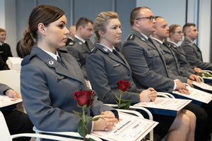 Policjantki siedzą w trakcie uroczystości.