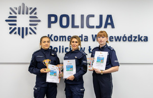 Policjanci trzymający w ręku dyplomy.