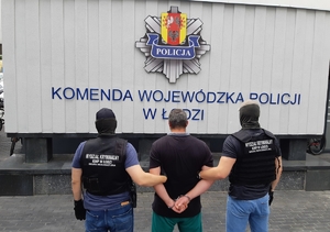 Policjanci prowadzą zatrzymanego.