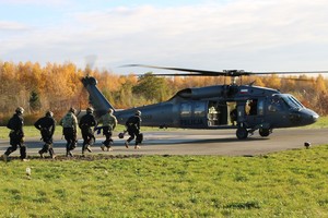 Policyjni kontrterroryści przed śmigłowcem policyjnym.