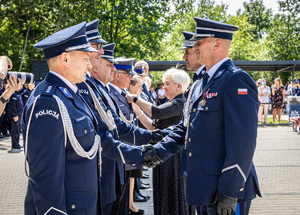 Na pierwszym planie Komendant Wojewódzki składa gratulacje wyróżnionym policjantom.